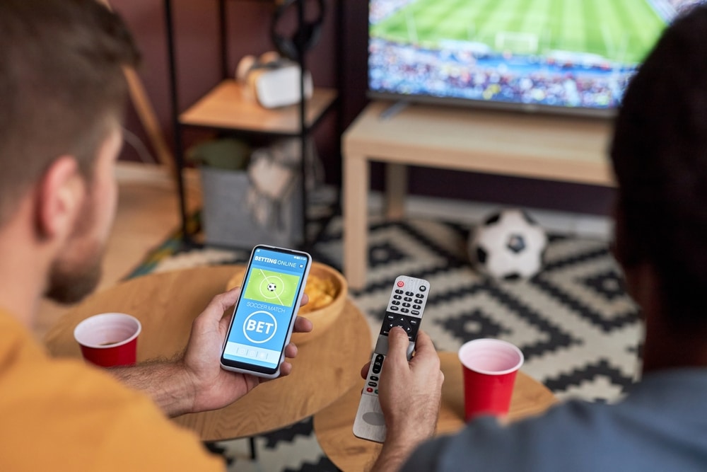 Mu&scaron;karac prati sportski događaj na mobitelu