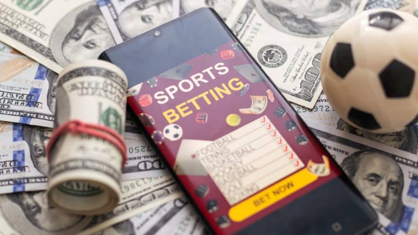 Mobitel s natpisom 'sports betting' na hrpi novaca (kako kladionice određuju koeficijente)
