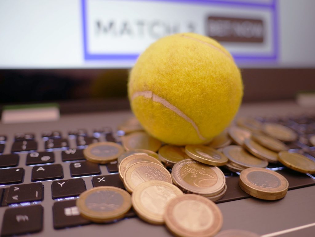Teniska loptica i kovanice eura na tipkovnici laptopa